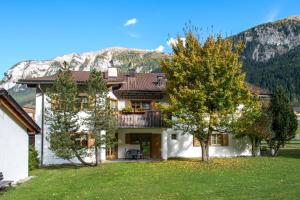 a house with a balcony in front of a mountain at Ferienwohnungen Muntschi in Andeer