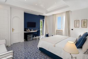 - une chambre avec un lit king-size et un bureau dans l'établissement Hotel Le Agavi, à Positano