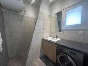 a bathroom with a washing machine and a sink at maison proche du Groupama Stadium in Décines-Charpieu