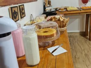 a table with a bottle of water and a bagel on it at Chalé Barco Recanto Buscapé SFX in São Francisco Xavier