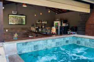 a swimming pool in a restaurant with a bar at Vale das Orquídeas Pousada in Socorro