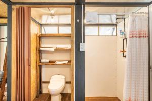 a bathroom with a toilet and a shower at Zil-Kaab Hidden Glamping Village in Tulum