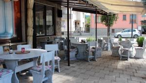 un patio avec des tables et des chaises en face d'un bâtiment dans l'établissement Хотел Хилез Hotel Hilez, à Tryavna