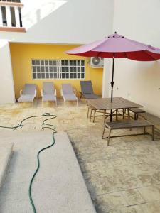 カンクンにあるCasa HS Cancúnのテーブルと椅子と傘のあるパティオ