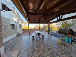 - une terrasse couverte avec une table et un grill dans l'établissement LOFT Huayna picchu, à La Falda