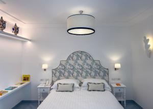 a bedroom with a bed with a blue and white headboard at Boutique Hotel Casa Mariantonia in Anacapri