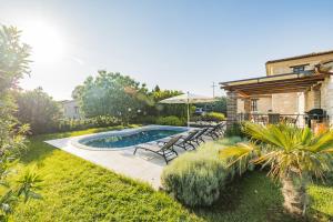 basen na dziedzińcu z krzesłami i parasolem w obiekcie Villa Jurinea in Istrien mit Pool w mieście Barat