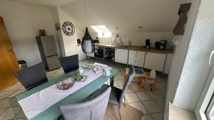 a kitchen with a table and chairs and a kitchen with a counter at Ferienwohnungen Hoheeifel in Kelberg +33 photos