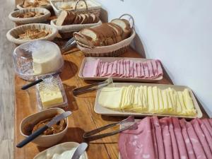 une table remplie de différents types de fromage et de pain dans l'établissement Chalé Tucano Recanto Buscapé SFX, à São Francisco Xavier