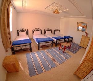 a room with four beds and a window at Riptide Surf House in Taghazout +18 photos