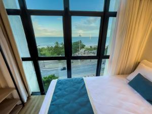 a bedroom with a large window with a view of the ocean at Marante Plaza Hotel in Recife