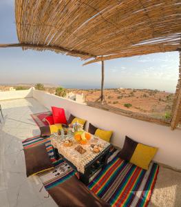 a table and chairs on a balcony with a view at Riptide Surf House in Taghazout