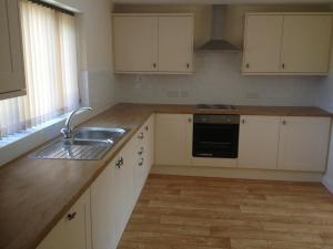 a kitchen with white cabinets and a sink at Forest View Holiday Park in Burscough
