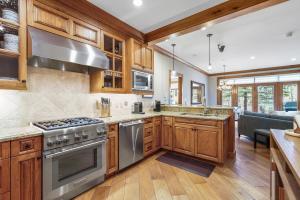 kuchnia z drewnianymi szafkami i urządzeniami ze stali nierdzewnej w obiekcie Ski-in Ski-out 1 BRDen in exclusive Horizon Pass condo w mieście Avon