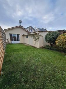 a white house with a yard with a fence at Maison au calme, proche de Paris in LʼHay-les-Roses