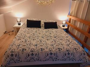 a bedroom with a bed with a blue and white comforter at Maison au calme, proche de Paris in LʼHay-les-Roses