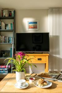 a living room with a table with a plate of food at The Byre, Heritage Escapes, Field House Farm in Bempton