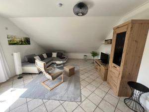 a living room with a couch and a chair at Ferienwohnungen Hoheeifel Nähe Nürburgring Platz für bis zu 10 Personen ,Verleih von zwei E-MTB möglich in Kelberg