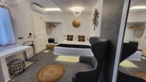Mykonos Double Luxury Mini Suites - Adults only في أنو ميرا: غرفة نوم بسرير وطاولة وكراسي