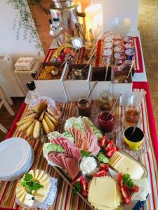 une table avec des amuse-bouches, du fromage et d'autres aliments dans l'établissement Haus Luca Seeblick, à Pörtschach am Wörthersee