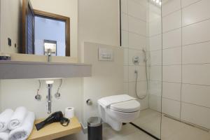 a white bathroom with a toilet and a shower at AEGEAN Apartments - Bungalows in Alacati