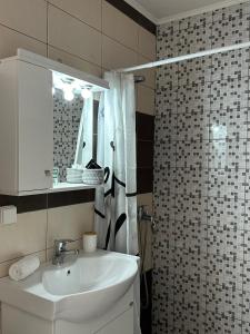ein Bad mit einem Waschbecken und einer Dusche in der Unterkunft Casa Di Rosse in Symi