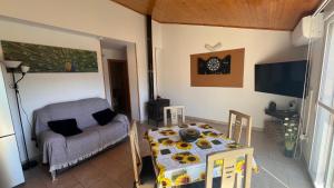 a living room with a table and a couch at CA LIDIA -Allotjament Rural ELCAMPANAR in Benimantell