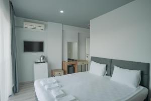 a bedroom with a white bed and a television at Birpa Kundu Hotel in Lara