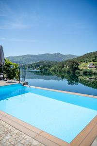 a swimming pool with a view of a lake at Lajinha do Ave in Azevedos
