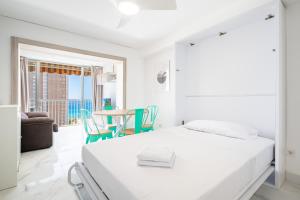 biała sypialnia z łóżkiem i stołem z krzesłami w obiekcie Albatros 12-8 Sea Views Levante Beach w mieście Benidorm