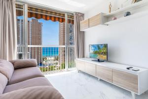 salon z telewizorem i dużym oknem w obiekcie Albatros 12-8 Sea Views Levante Beach w mieście Benidorm
