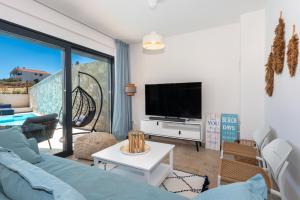 ein Wohnzimmer mit einem blauen Sofa und einem TV in der Unterkunft Villa Navy Lemon in Vodice