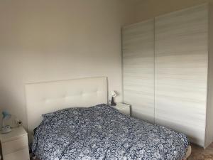 um quarto com uma cama grande e uma parede branca em SELENE CASA em Prato