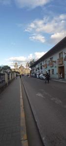 a street in a town with buildings and a person walking down the street at Hotel Aural in Cajamarca