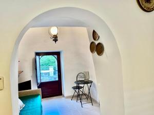 a hallway with a door and a table with a stool at Trulli Duomo di Calce in Alberobello