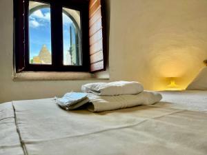 a bed with two pillows on it in a room with a window at Trulli Duomo di Calce in Alberobello