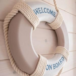 a wreath on a door with the words welcome on board at Hausboot Kaddi`s SunDREAM - Huus & Meer in Fehmarn