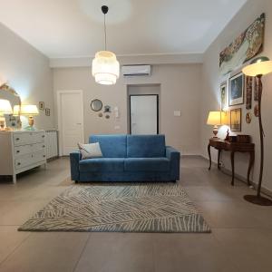ein Wohnzimmer mit einem blauen Sofa und einem Teppich in der Unterkunft Le Giramondo Appartamento Carolina in Caserta