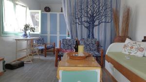 a living room with a bed and chairs and a table at Elies apartments 2 in Alinda