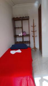 ein Schlafzimmer mit einem roten Bett mit einer roten Decke in der Unterkunft Pousada & Camping Recanto dos Anjos Azuis in Paty do Alferes