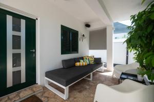 a living room with a black couch and a green door at Holiday Home LI-ZA in Privlaka