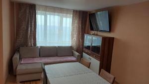 a small living room with a couch and a television at VP Apartment Sillamäe in Sillamäe