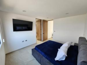 a bedroom with a couch and a flat screen tv at Casa de Lujo con Jacuzzi in Querétaro