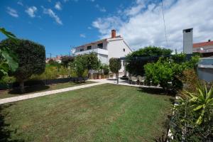 a view of a yard with a white house at Holiday Home LI-ZA in Privlaka