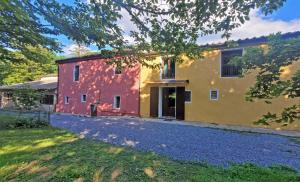 une maison avec un bâtiment rouge et jaune dans l'établissement Locanda Le Panche, à Pistoia
