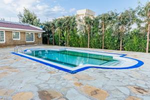 a swimming pool in a yard with a stone patio at Golden View Manor in Naivasha