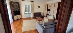 een woonkamer met een bank, stoelen en een tafel bij Apartman Nikolino in Sukošan