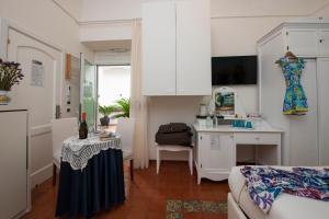 una camera con cucina e un soggiorno con tavolo di Hotel Antica Repubblica in Amalfi center at 100mt from the sea with payment parking ad Amalfi