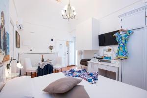 um quarto branco com uma cama e uma sala de jantar em Hotel Antica Repubblica in Amalfi center at 100mt from the sea with payment parking em Amalfi