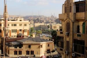 Blick auf eine Stadt mit Gebäuden und einer Moschee in der Unterkunft Hostel Sunset Down town in Kairo